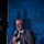 Next-Generation Battle Management - AFA Panel A middle-aged man with gray hair and a beard is seated in a chair, speaking into a microphone branded with the AFA (Air Force Association) logo. He is dressed in a gray suit with a white shirt and an orange-and-white striped tie. The event backdrop displays the AFA 'Air & Space Forces Association' branding prominently.