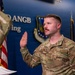 A U.S. Air Force senior non-commissioned officer is taking an oath of office or reenlistment ceremony at what appears to be an Air National Guard Base (ANGB). The service member, whose name tag reads 'DURANT,' is raising his right hand while facing an officiating officer. The setting includes official military insignia, an Air Force shield emblem, and an American flag.