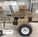 The image shows a trailer-mounted 'LEGI Series' snow block press machine photographed inside an industrial warehouse or workshop. The machine is tan/beige colored and features annotated labels indicating the snow processing workflow: processed snow enters via a top hopper, pressure is applied in the middle chamber, and compressed snow blocks exit from the side. The equipment appears to be new or well-maintained and is designed to be towed by a vehicle via its hitch assembly.