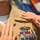 C3F conducts Chief pinning ceremony A close-up image showing two sets of hands pinning insignia onto a U.S. Navy officer's khaki uniform during what appears to be a promotion or award ceremony. The uniform displays a Surface Warfare Officer (SWO) badge and multiple service ribbons. The ceremonial pinning suggests a formal military milestone event.