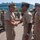 C3F conducts Chief pinning ceremony A senior U.S. Navy officer, identifiable by gold scrambled-egg insignia on his cover and what appear to be admiral's stars on his collar, is shaking hands with an enlisted sailor during what appears to be an outdoor military ceremony or event. The sailor receiving the handshake has a visible Polynesian-style tattoo on his right arm and is wearing ribbons/awards on his uniform. Multiple Navy personnel in tan Service Uniform C (SUC) are visible in the background.