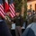 Oleszno cultural center dedicated to Staff Sgt. Michael Ollis, honoring U.S.-Poland bond A formal military ceremony is taking place outdoors, featuring personnel from both the United States Army and the Polish Armed Forces. Two senior officers are engaged in a handshake, suggesting an official greeting, award presentation, or bilateral military engagement. American and Polish flags are prominently displayed in the background, indicating a joint or allied military event.