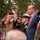 Attendees Render Honors at the LT John S Thompson Bridge Ceremony, Operation Market Garden Commemorations 2026 A formal military and civic ceremony is taking place outdoors, likely a commemoration or memorial event. Several individuals in military uniforms and civilian formal attire are standing at attention, with some rendering salutes. The presence of a mayoral chain of office and military decorations suggests an official public ceremony of significant importance.