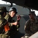 The image shows military personnel from at least two different armed forces engaged in what appears to be a briefing or discussion inside or alongside a military vehicle. One soldier wearing a black helmet and Japanese Ground Self-Defense Force (JGSDF) camouflage pattern uniform is speaking and gesturing, while a U.S. Army soldier in MultiCam/OCP uniform listens attentively. This appears to be a joint military exercise or training event between Japanese and American forces.