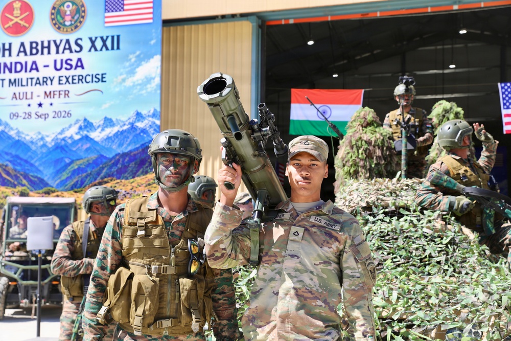 The image depicts a joint India-USA military exercise called 'Yudh Abhyas XXII' held at Auli, India, scheduled from 09-28 September 2026. Soldiers from both the U.S. Army and Indian Army are visible in full combat gear, with one U.S. soldier prominently holding a shoulder-fired rocket launcher. Both national flags and official exercise banners are displayed in the background.