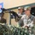 Yudh Abhyas 2026: U.S., Indian Soldiers exchange weapons, equipment knowledge in Auli The image shows a joint military exercise between U.S. Army and Indian Army personnel, as indicated by the flags and banner visible in the background reading 'S XXII' and 'EXERCISE'. Two U.S. Army soldiers in OCP (Operational Camouflage Pattern) uniforms are positioned behind a camouflage-netted emplacement with a mounted machine gun, alongside an Indian soldier in combat face paint and helmet. The setting appears to be a demonstration or training event.