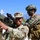 Yudh Abhyas 2026: U.S., Indian Soldiers exchange weapons, equipment knowledge in Auli The image shows military personnel from what appears to be a joint training exercise between U.S. Army and Indian Army soldiers. A smiling U.S. soldier in MultiCam uniform is handling a shoulder-fired rocket launcher (appears to be an AT4 or similar weapon system), while an Indian Army soldier in distinctive camouflage with an Indian flag patch assists. The setting appears to be a mountainous region, likely in northern India based on the terrain and context.