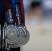 The image shows a collection of finisher medals from the Marine Corps Half Marathon held at Camp Lejeune in 2026. The medals are silver-toned and feature the iconic Eagle, Globe, and Anchor emblem of the United States Marine Corps. They are suspended on navy blue and maroon ribbons with 'Marine Corps Half Marathon' printed on them.