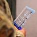 A military service member in camouflage uniform holds a crystal glass award trophy. The award is engraved with 'CGO of the Quarter' for the Nevada Air National Guard, presented to 1st Lt Lauren Hernandez of the 152 CPTF for the 2nd Quarter 2026. The trophy features a blue base and jagged crystal top with an engraved unit emblem.
