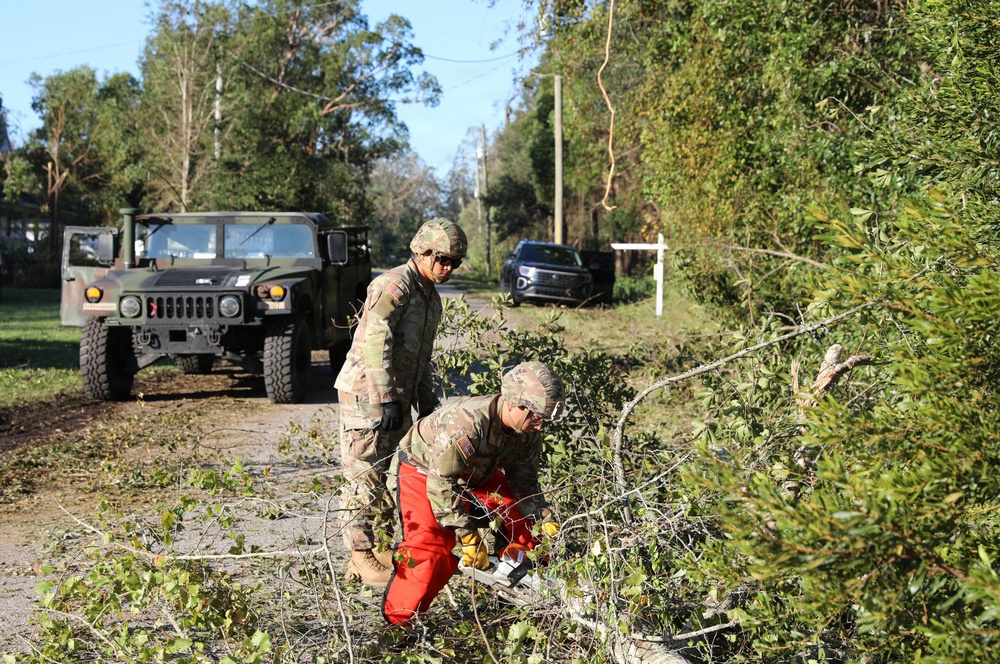 National Guard Soldiers and Airmen clear road in...