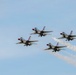 Four U.S. Air Force Thunderbirds demonstration team aircraft fly in a tight diamond formation against a clear blue sky. The jets, identifiable by their distinctive red, white, and blue livery, are producing white smoke trails from at least two of the aircraft. This appears to be an airshow performance showcasing precision formation flying.